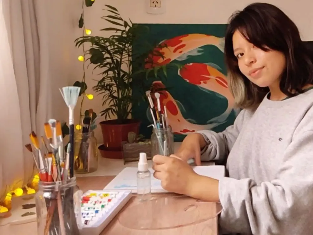 Gisela en su mesa de trabajo con pinceles y acuarelas