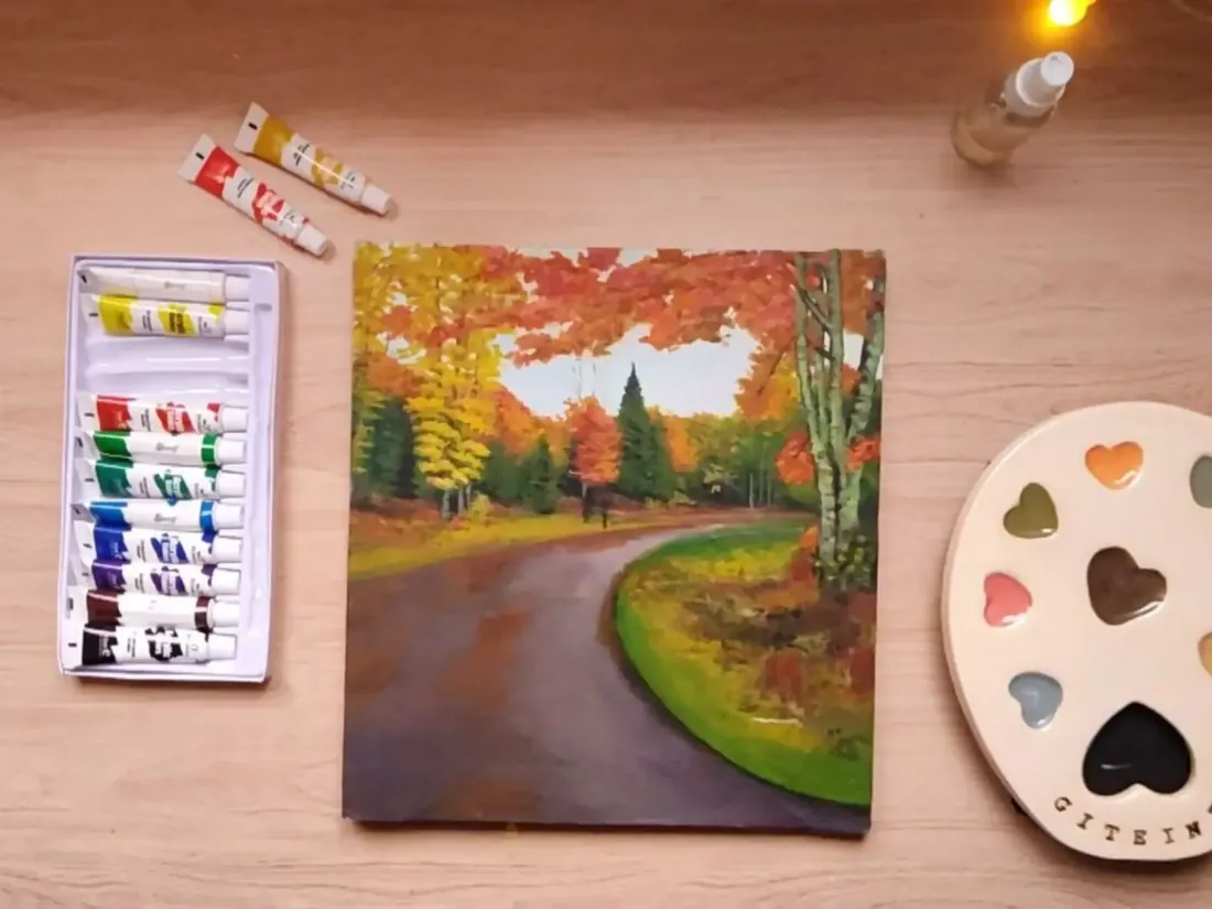 Paisaje de otoño terminado junto a las pinturas y la paleta
